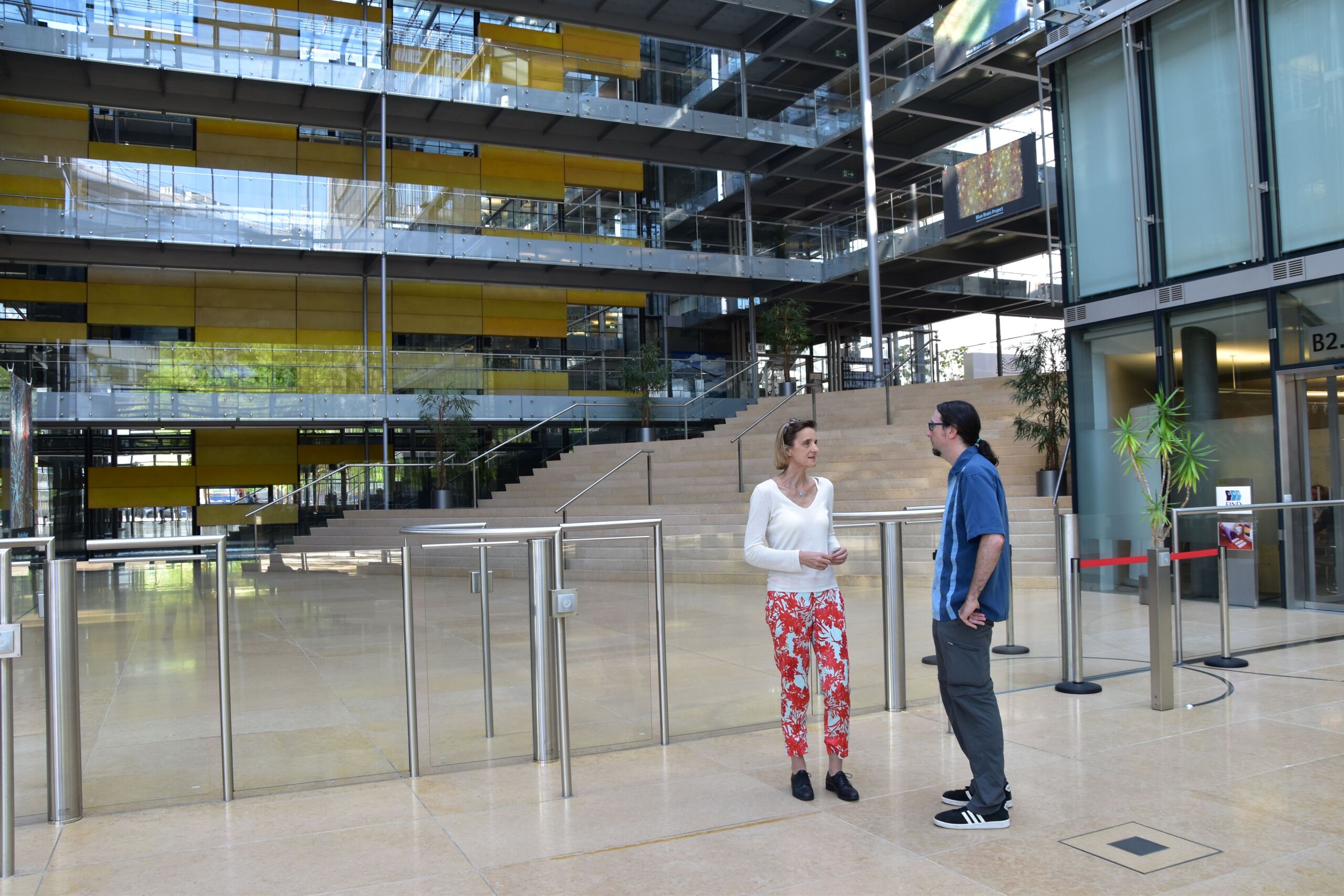 Daphne Bavelier talks to a man in front of an office building